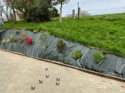 Jardin de l'établissement Gîte des Pommiers avec terrain de pétanque
