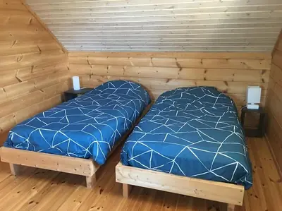 Un ou plusieurs lits dans un hébergement de l'établissement Charmante maison en bois proche mer