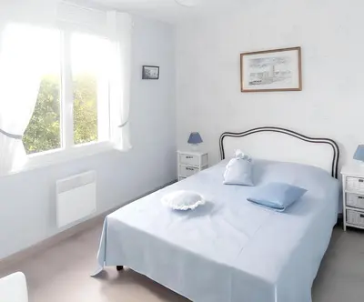 Un ou plusieurs lits dans un hébergement de l'établissement Maison charmante à Portbail avec jardin et vue mer