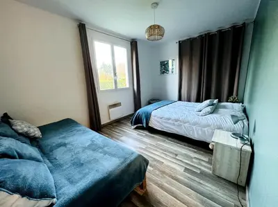 Un ou plusieurs lits dans un hébergement de l'établissement Maison rénovée et chaleureuse proche du mémorial