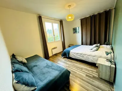 Un ou plusieurs lits dans un hébergement de l'établissement Maison rénovée et chaleureuse proche du mémorial