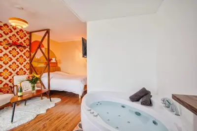 Un ou plusieurs lits dans un hébergement de l'établissement Suite année 70 - Jacuzzi et Balcon