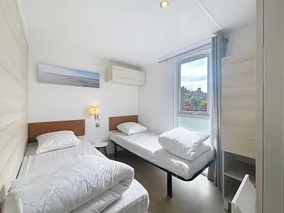 Un ou plusieurs lits dans un hébergement de l'établissement Mobil-home luxueux à Jullouville, 200m plage, piscine chauffée, pour 6 personnes - FR-1-361A-73