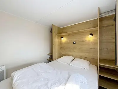 Un ou plusieurs lits dans un hébergement de l'établissement Tiny House bois avec terrasse, piscine, wifi, animaux admis, parking - 200m de la plage - FR-1-361A-88