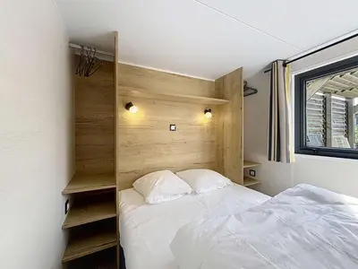 Un ou plusieurs lits dans un hébergement de l'établissement Tiny House bois avec terrasse, piscine, wifi, animaux admis, parking - 200m de la plage - FR-1-361A-88