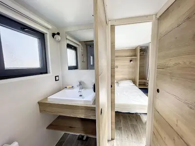 Un ou plusieurs lits dans un hébergement de l'établissement Tiny House cosy près de la plage avec piscine et parking - FR-1-361A-94