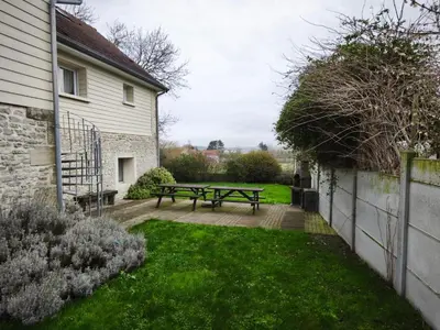 Jardin de l'établissement Ecume maison spacieuse lumineuse 1km de la plage vue mer plage d'Asnelles, en plein coeur des plages du débarquement, 2 sdb, 2 WC, parking privatif, terrasse, jardin, table de ping pong aux beaux jours, près de Bayeux