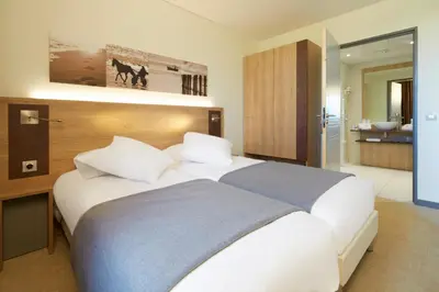 Un ou plusieurs lits dans un hébergement de l'établissement Kyriad Prestige Residence & Spa Cabourg-Dives-sur-Mer