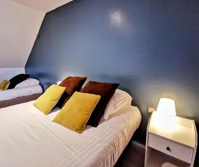 Un ou plusieurs lits dans un hébergement de l'établissement Hôtel Restaurant Le Mulberry Arromanches