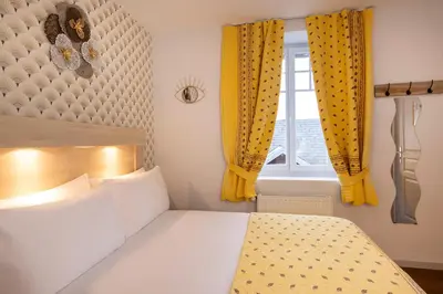 Un ou plusieurs lits dans un hébergement de l'établissement Hôtel de Lion sur Mer