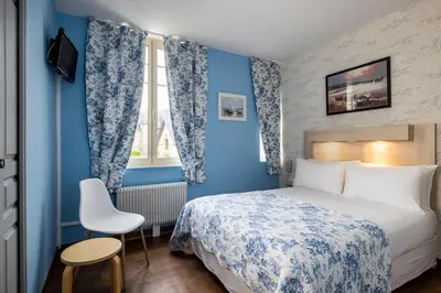 Un ou plusieurs lits dans un hébergement de l'établissement Hôtel de Lion sur Mer