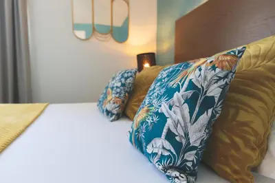 Un ou plusieurs lits dans un hébergement de l'établissement Hôtel Les Coutainvillaises