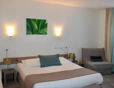 Un ou plusieurs lits dans un hébergement de l'établissement Brit Hotel Alghotel