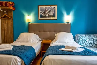 Un ou plusieurs lits dans un hébergement de l'établissement Hotel La Voilerie Cancale bord de mer