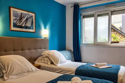 Un ou plusieurs lits dans un hébergement de l'établissement Hotel La Voilerie Cancale bord de mer