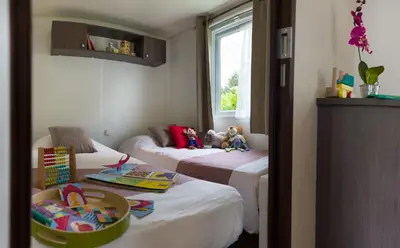 Un ou plusieurs lits dans un hébergement de l'établissement Camping Officiel Siblu Domaine de Litteau