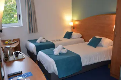 Un ou plusieurs lits dans un hébergement de l'établissement BRIT HOTEL Caen Hérouville