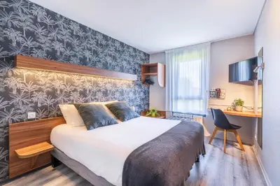 Un ou plusieurs lits dans un hébergement de l'établissement Logis Hôtel Restaurant Le Sainte Mère