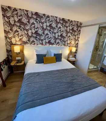 Un ou plusieurs lits dans un hébergement de l'établissement Hôtel Le Pavillon de Saint-Lô