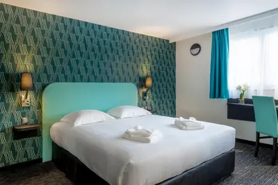 Un ou plusieurs lits dans un hébergement de l'établissement Zenith Hotel Caen