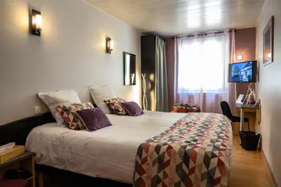 Un ou plusieurs lits dans un hébergement de l'établissement Hôtel Le Bayeux