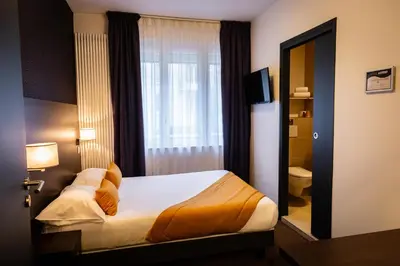 Un ou plusieurs lits dans un hébergement de l'établissement Hotel Astrid Caen centre