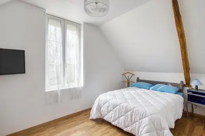 Un ou plusieurs lits dans un hébergement de l'établissement Maison charmante à Saint-Marcouf avec jardin.