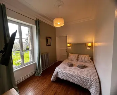 Un ou plusieurs lits dans un hébergement de l'établissement Les chambres d'Omaha Beach Etablissement avec deux chambres d'hôtes, petit-déjeuner compris fait-maison et produits locaux