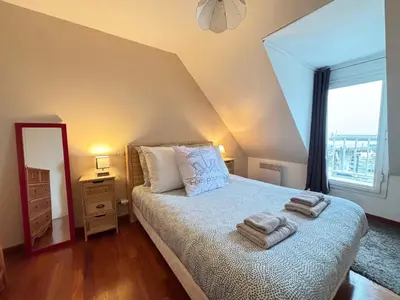 Un ou plusieurs lits dans un hébergement de l'établissement Côté cottage Apt 3 chambres bien équipé vue imprenable sur le port et la mer plein centre de Port en Bessin commerces et restaurants à pied proche Omaha Beach parking gratuit à proximité