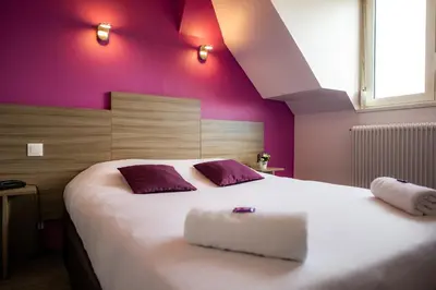 Un ou plusieurs lits dans un hébergement de l'établissement Logis Hotel Du Chateau