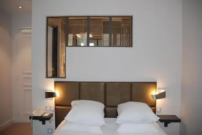 Un ou plusieurs lits dans un hébergement de l'établissement Logis Hôtel Restaurant Le Dauphin et Le Spa du Prieuré