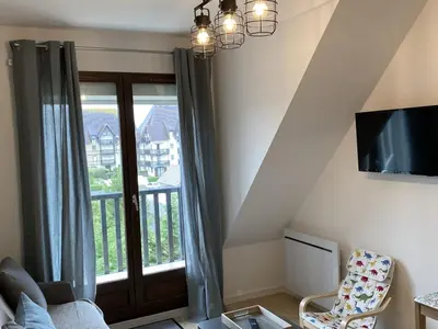Coin salon dans l'établissement Appartement rénové proche plage et thalasso, 2 pièces, balcon, Wifi, TV, équipements bébé - Cabourg - FR-1-487-322