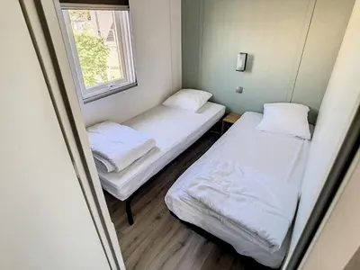 Un ou plusieurs lits dans un hébergement de l'établissement Mobil-home 35m², 3 chambres, terrasse couverte, piscine chauffée, à 200m de la plage, Jullouville - FR-1-361A-6
