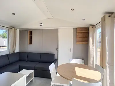Coin salon dans l'établissement Mobil-home confort 4 pers, 2 ch, piscine chauffée, 200m plage, parking, wifi gratuit, animaux ok - FR-1-361A-32