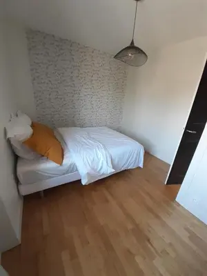 Un ou plusieurs lits dans un hébergement de l'établissement Maison chaleureuse, spacieuse et familiale